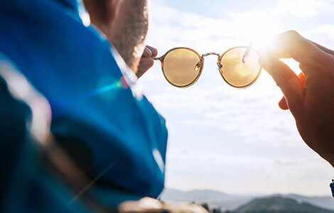 Person Holding Up Glasses to the Sun